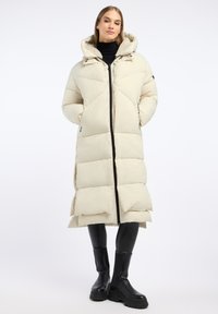 Padded long coat in light beige with a zip front, large hood, and side pockets. Features quilted design and black accents.