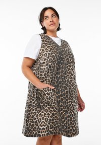 Leopardprint mouwloze jurk met een V-hals, twee voorzakken en een relaxte pasvorm, gemaakt van textiel met zwart en bruin tinten.