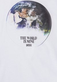 T-shirt bianca con una grafica colorata della Terra racchiusa da un contorno circolare e il testo "IL MONDO È MIO" sopra il logo "DIESEL" in basso.