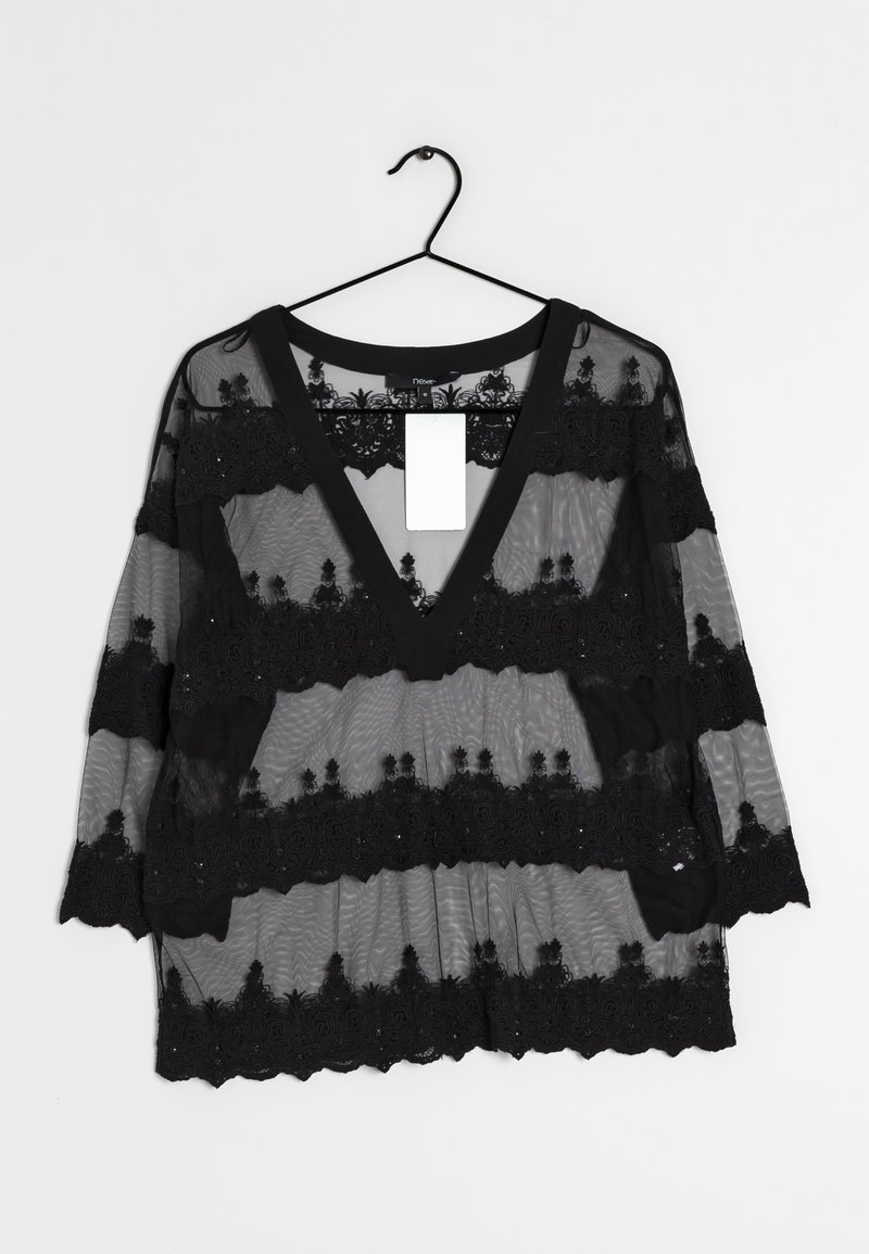 Schwarze transparente Bluse mit V-Ausschnitt, verziert mit gestickten Spitzenmustern an den Ärmeln und dem Körper sowie einem einfarbigen schwarzen Saum am Halsauschnitt.