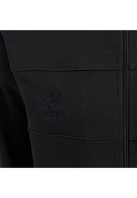 Felpa nera con chiusura a zip, tessuto testurizzato, con logo ricamato nella zona del taschino sinistro.
