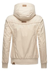 Veste à capuche beige avec manches longues, poignets et ourlet côtelés, et petites étiquettes de marque brunes à l'arrière et sur l'ourlet inférieur.