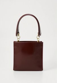 Neliönmuotoinen, tummanruskea nahkalaukku, jossa on jämäkkä muotoilu ja leveä yksittäinen kahva, joka on kiinnitetty kultaisilla metallisormuksilla valkoisella taustalla.