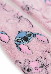 Tessuto morbido di colore rosa con una trama che presenta un motivo ripetuto di personaggi dei cartoni animati con accenti blu, rosa e neri, che mette in risalto una texture soffice.