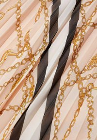 Un tessuto testurizzato in tonalità di rosa e crema presenta un motivo a catena in toni dorati e strisce nere, creando un design dinamico.
