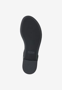 Suola di scarpa in gomma nera con una superficie testurizzata, caratterizzata da una curva centrale e un'impronta del logo. Il design offre stabilità e aderenza.