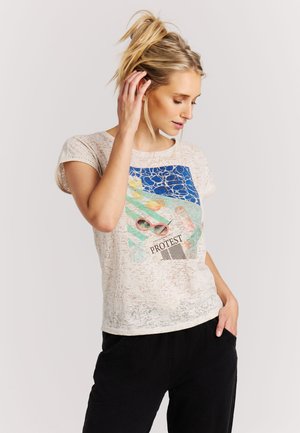 Cream, lightweight t-shirt with short sleeves, featuring a colored graphic of sunglasses and abstract shapes. Black pants visible.