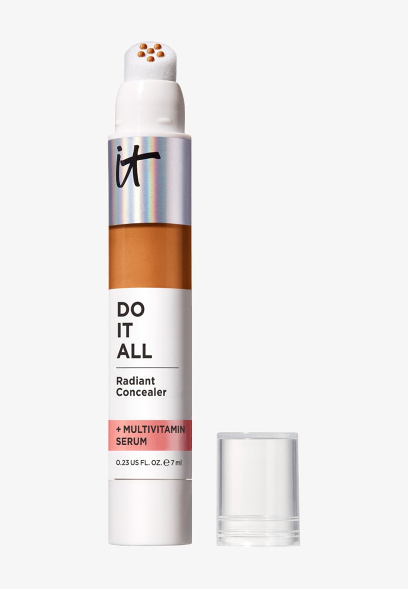 Bâton correcteur avec applicateur coussin montrant neuf points de sérum, étiqueté "Do It All Radiant Concealer + Sérum Multivitaminé".