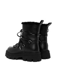 Botas negras de cuero con cordones que cuentan con una suela de goma gruesa, un borde de piel sintética en la parte superior y acentos de hardware metálico. Diseño de caña alta.