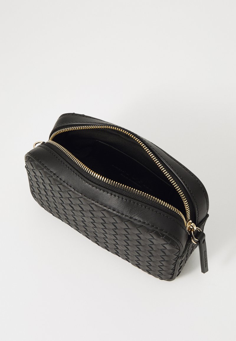 Schwarze geflochtene Lederhandtasche mit Reißverschluss, ausgestattet mit goldfarbenen Beschlägen und einem offenen Innenraum. Kompakte, rechteckige Form.