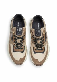 Brown and beige sneakers with a mix of smooth and textured materials, featuring black laces with gold eyelets and a chunky white sole.
