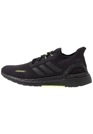 Czarne buty do biegania Adidas z dzianinową cholewką, czarną podeszwą, neonowymi zielonymi pętelkami na sznurówki oraz etykietą "AEROREADY" z boku.
