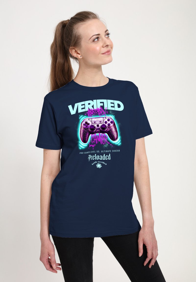 Camiseta navy con un gráfico de un controlador de videojuegos en color púrpura, texto en negrita "VERIFICADO" y acentos juguetones. Tejido de algodón suave, mangas cortas.
