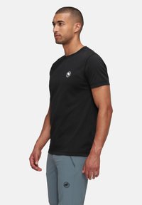 Zwarte t-shirt met korte mouwen en een ronde halslijn, voorzien van een klein logo op de borst. Gemaakt van zacht materiaal met een klassieke pasvorm.