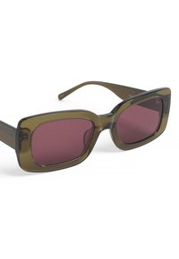 Lunettes de soleil rectangulaires avec des montures vert olive foncé et des verres bordeaux. Fini brillant, branches épaisses et accents matériels subtils sur les côtés.