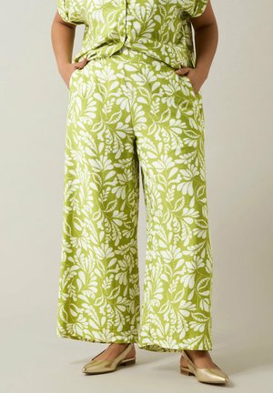 Pantalons larges en mélange de lin couleur vert clair avec des motifs floraux blancs, dotés d'une taille élastique et de poches latérales.