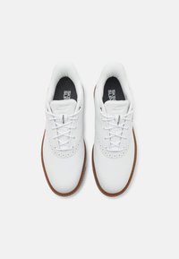 White leather shoes with perforated accents, round toe, and flat laces. Features a cushioned insole and tan rubber outsole.