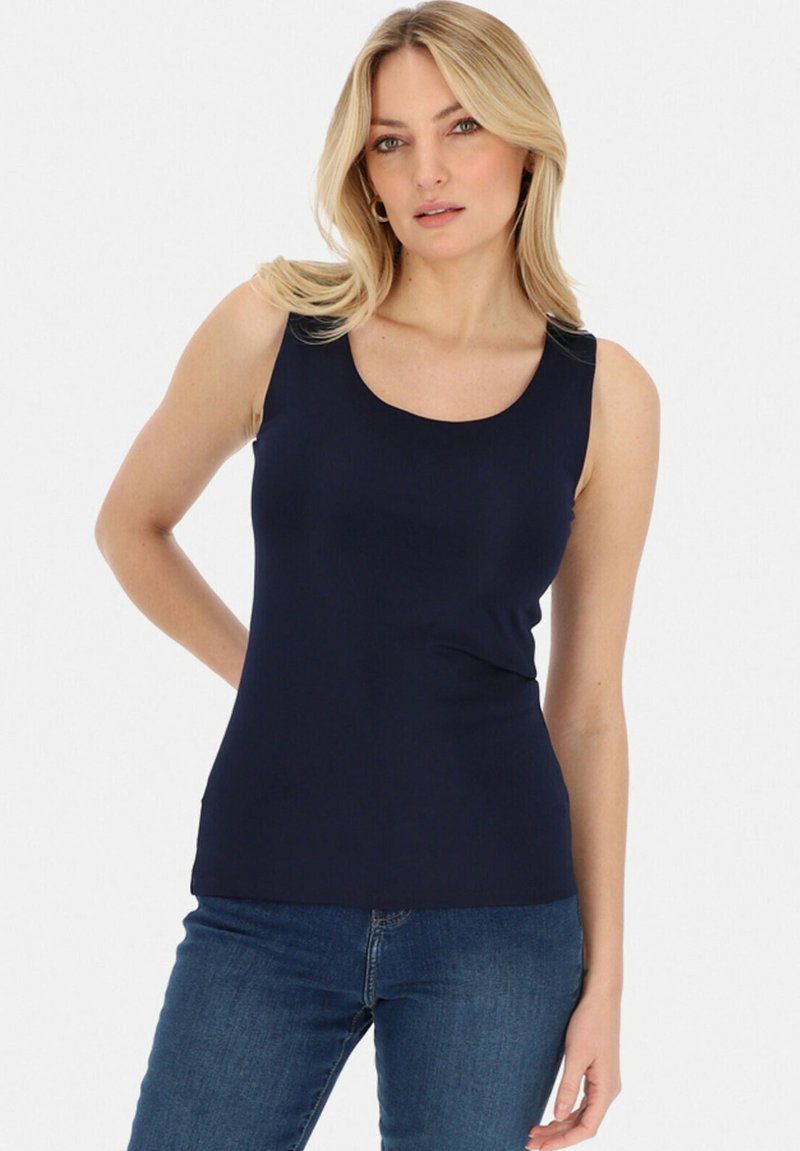 Granatowy dopasowany top na ramiączkach z okrągłym dekoltem i szerokimi ramiączkami. Miękki, elastyczny materiał o gładkiej teksturze, w połączeniu z dżinsami w stylu casual.