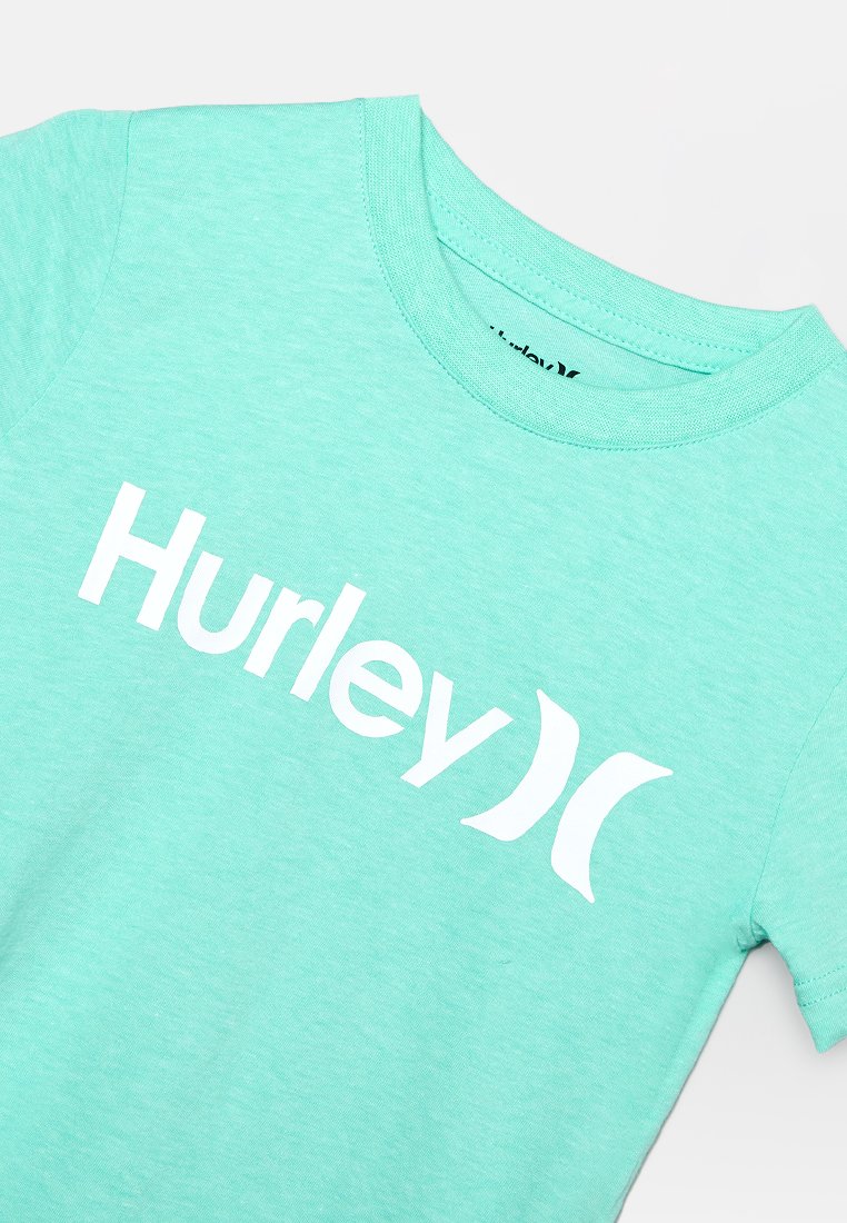 Mintgroene korte mouw t-shirt gemaakt van zachte stof, met een groot wit "Hurley" logo op de borst, vergezeld van twee gebogen accenten.