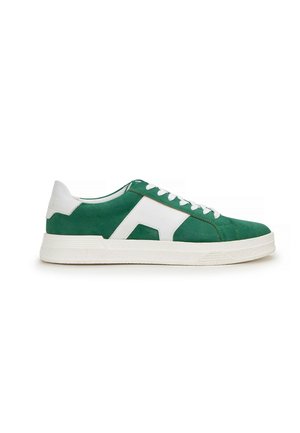 Zapatilla baja de ante verde con detalles en piel blanca, cordones blancos y una suela gruesa de goma blanca, vista desde el lado exterior.