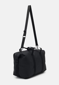 Borsone nero realizzato in materiale testurizzato e resistente all'acqua. Dotato di doppie maniglie superiori e di una lunga tracolla regolabile. Design minimalista.