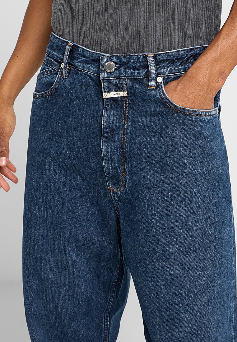 Dunkelblaue Denim-Jeans mit hoher Taille, geradem Schnitt und kontrastierenden orangenen Nähten. Verfügt über Vordertaschen und einen Metallknopfverschluss.