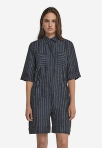 Mörkblå, randig jumpsuit med korta ärmar, knapplistkrage, två bröstfickor och uppvikta manschetter vid fållen. Linneliknande textur.