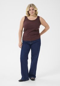 Brown tank top with a round neckline paired with dark blue wide-leg jeans. Simple design, smooth texture, and no visible patterns or embellishments.