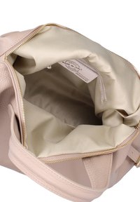 Borsa a mano in pelle beige con zip dorata, interno in tessuto beige e tasca interna con zip etichettata "Made in Italy."