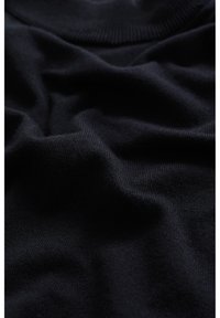 Černá pletená l átka s hladkou texturou a žebrovaným výstřihem. Materiál působí měkce a jemně se přizpůsobuje tvaru.