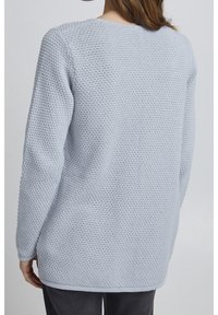Light blue knitted sweater with a textured pattern, round neckline, and long sleeves, featuring a relaxed fit and ribbed hem.