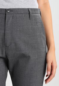 Grå skräddarsydda byxor i textil, med knäppning, sidofickor och en slät midja.