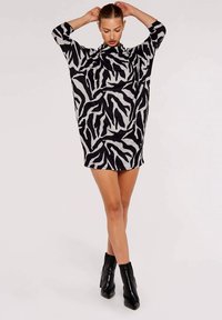 Schwarzes und graues, übergroßes Kleid mit Zebra-Streifenmuster, mit höherem Ausschnitt und drei Viertelärmeln, aus weichem, strukturiertem Stoff gefertigt.