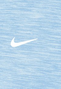 Des vêtements Nike présentant une texture bleu clair chiné avec un logo swoosh blanc bien en vue. Le tissu paraît doux et léger.