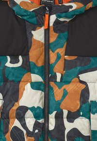 Padded bunda s kamuflážním vzorem v barevných kombinacích modré, oranžové, černé a krémové. Disponuje zipovým uzávěrem a černou kapucí s texturovaným materiálem.