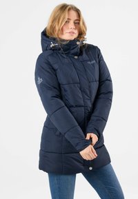 Navy blue puffer jacket with a hood, featuring a zip closure, elastic cuffs, and shaped stitching. Logo detail on the sleeve.
