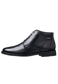Bottines en cuir noir avec une finition lisse, bout rond, fermeture lacée à l'avant et logo discret sur le côté. Talon en caoutchouc noir bas.