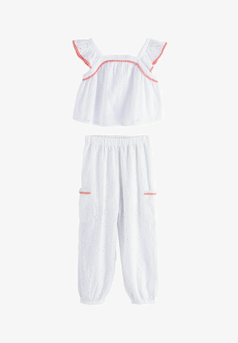 Bílý dvojdílný bavlněný outfit s výšivkou. Tílko má volánové rukávy a růžový lem; kalhoty mají pružný pas a kapsy.
