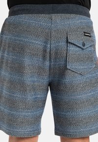 Pánské šortky v modro-šedém herringbone vzoru s texturovaným povrchem. Obsahují zadní kapsu s knoflíkem a brandingovou nášivkou.