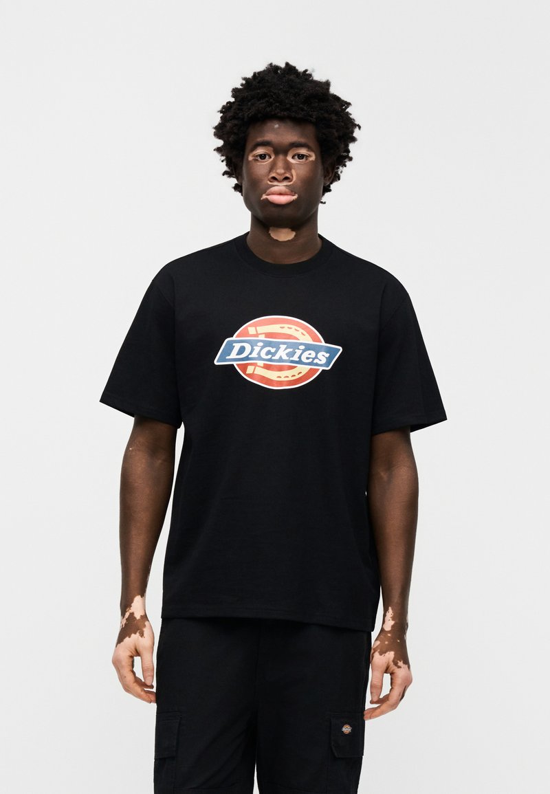 T-shirt nera in cotone con un grande logo "Dickies" colorato al centro. Maniche corte, vestibilità comoda, scollo rotondo.