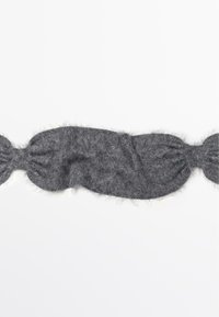 Serre-tête gris en peluche fabriqué dans un matériau doux, avec un design allongé, des extrémités froncées et une surface lisse et texturée.