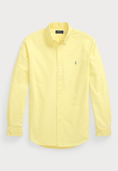 Yellow long-sleeve shirt made of cotton. Features button-down collar, front placket, and small embroidered logo on the left chest.