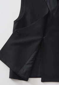 Schwarze Weste mit einer glatten, strukturierten Außenseite, breitem Revers, offenem Vorderteil und einer inneren Fütterung in einem kontrastierenden dunklen Farbton.