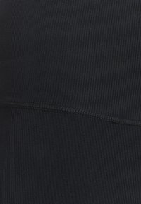 Tessuto nero a costine con una texture liscia, caratterizzato da una cucitura orizzontale e un leggero stretch per il comfort. Senza motivi o hardware visibile.