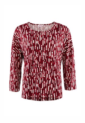Rote und weiße gemusterte Bluse mit lockerer Passform, runder Halslinie und Dreiviertelärmeln. Der Stoff hat eine glatte Textur mit einem geometrischen Design.