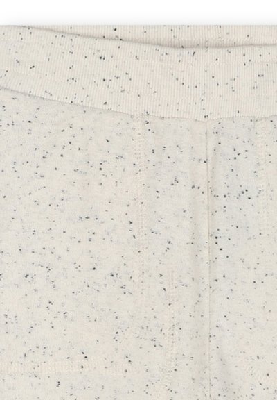 Lichtbeige stof met zwarte spikkels, met een geribde tailleband en een zachte textuur. Het ontwerp bevat subtiele stikdetails en heeft geen patronen.