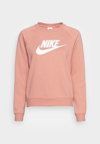 Rosa sweatshirt i mjukt tyg med en vit Nike-logotyp i mitten, ribbade muddar och rundad halsringning. Långa raglanärmar.