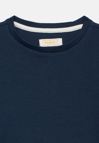 Μπλούζα μπλε ναυτικό με ριγέ υφή, στρογγυλή λαιμό κοψη, εσωτερική επένδυση σε ανοιχτό χρώμα για αντίθεση και ραμμένη ετικέτα με το κείμενο "FRIBOO".