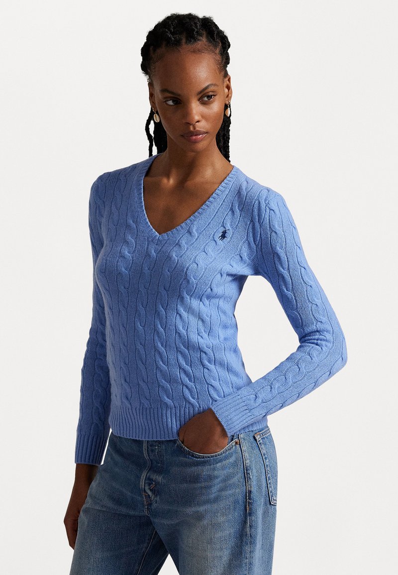 Kabelgebreid v-hals sweater in lichtblauw, met lange mouwen en ribgebreide zoom. Klein logoaccent aan de linkerkant.