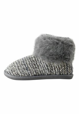 Bačkory s šedým umělým kožešinovým lemem a vzorovaným šedobílým pleteným svrškem. Mají plochou šedou podrážku.